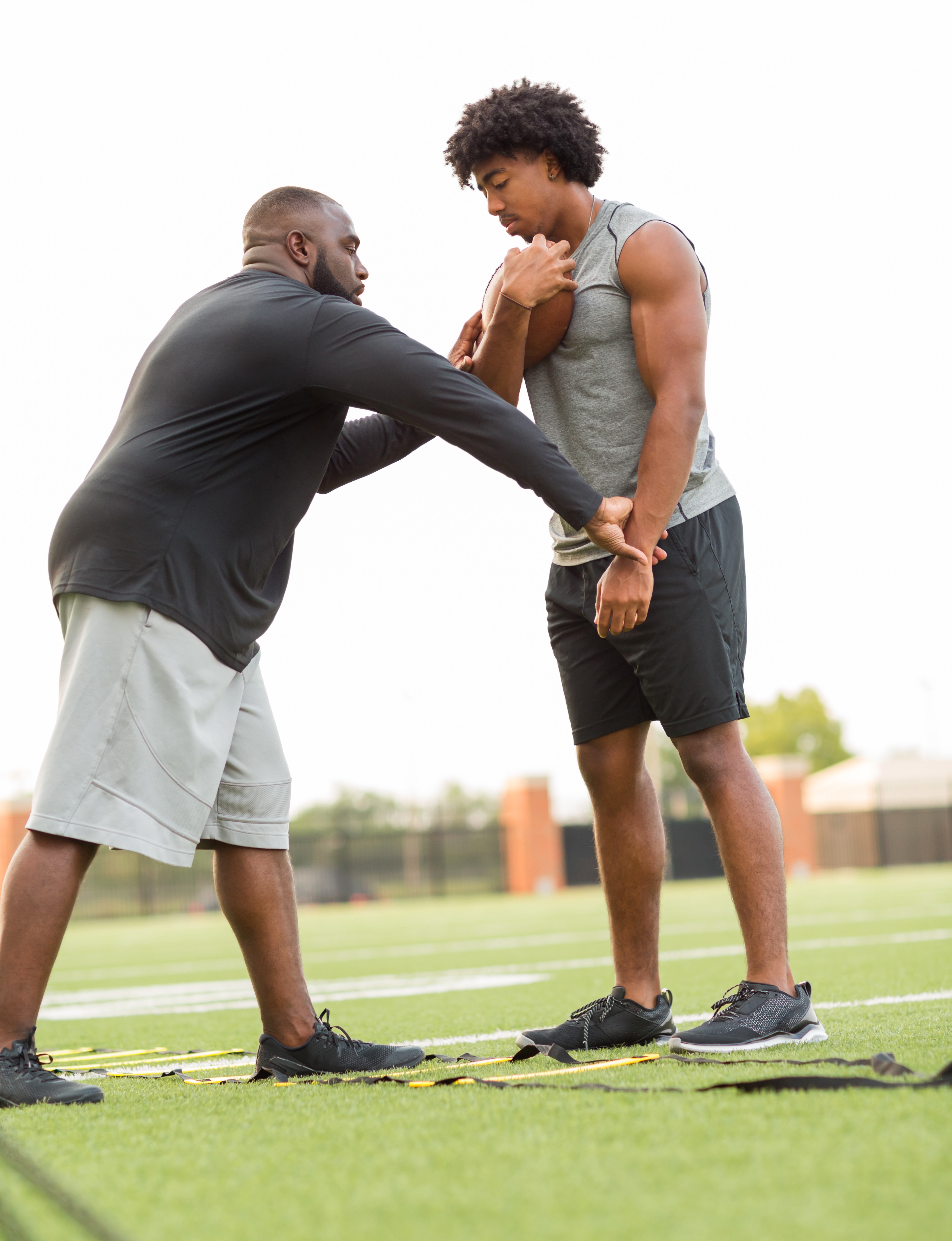 American Football coach training a young athlete.
